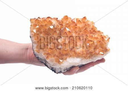 Citrine druzy cluster in woman's hands isolated on white background