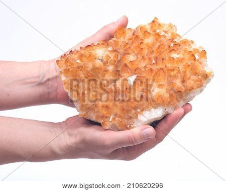 Citrine druzy cluster in woman's hands isolated on white background