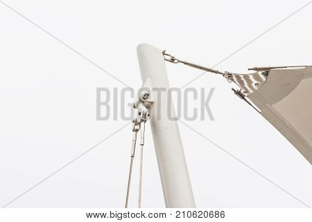 Construction details : Stainless steel support to round steel post of roof canvas with white sky background