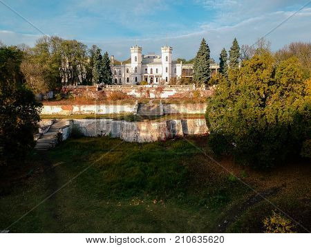 Aerial view on abandoned ruined castle and park. Autumn color image in sunset light.