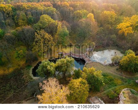 Aerial view on abandoned ruined castle and park. Autumn color image in sunset light.