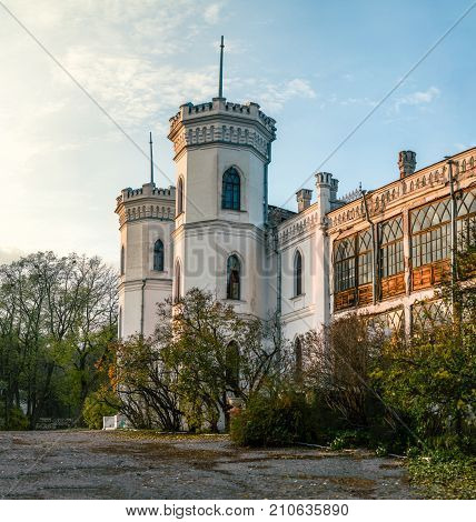 View on abandoned ruined castle and park. Autumn color image in sunset light.