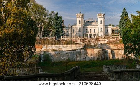 View on abandoned ruined castle and park. Autumn color image in sunset light.