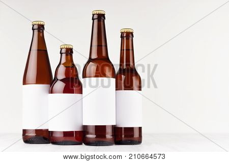 Brown beer bottles collection different type with blank white label on white wooden board mock up. Template for advertising design branding identity.