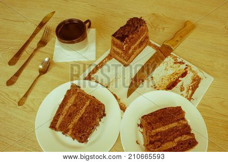 Coffee cup and chocolate cake onon wooden table. Coffee and a piece of cake - Retro color