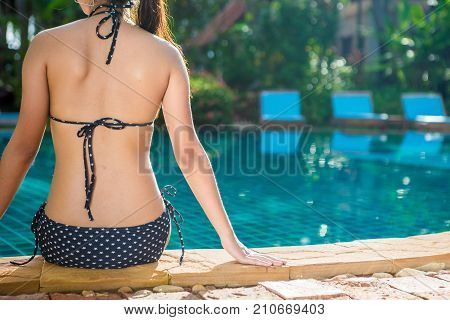 Women wearing bikini or swimware suits at swimming pool at the resort of Pattaya in Thailand.