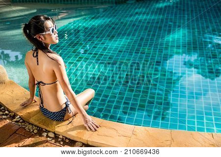 Women wearing bikini or swimware suits at swimming pool at the resort of Pattaya in Thailand.
