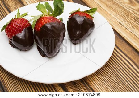 berry ripe strawberries in chocolate on a wooden background