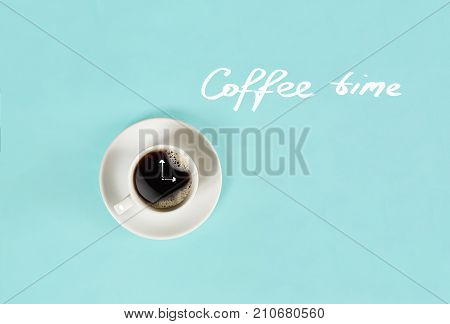 Top view of cup of black coffee and Coffee time lettering isolated on blue background. Still life. Mock up. Flat lay