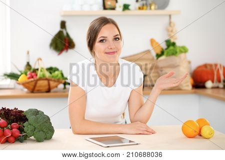 Young woman is making online shopping by tablet computer and credit card. Housewife found new recipe for  cooking in a kitchen