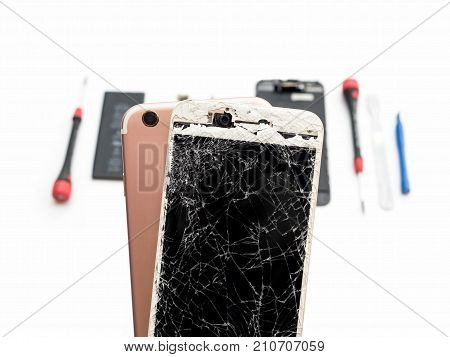 Close-up of cracked smartphone screen on blurred smartphone component background