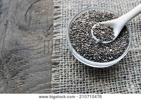 Chia seeds in a glass bowl on old wooden background.Organic chia seeds.Healthy food,superfood or bodycare concept.Selective focus.