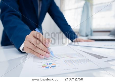 Business and finance investment concept. Businessman calculate about cost and doing finance at office Finance managers taskBusinessman recheck new plan financial graph data.