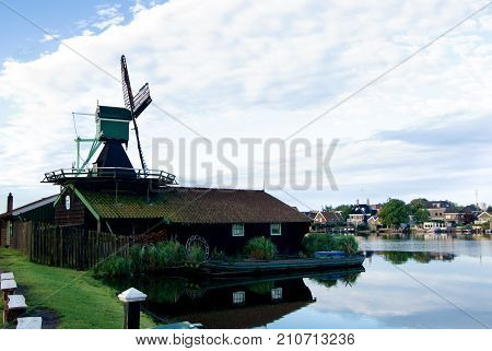 Famous Zaanse Schans Saw Windmill Het Klaverblad with Reflection on Water Early Morning Outdoors