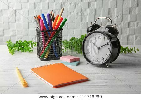 Time management concept. Composition with alarm clock on wooden table