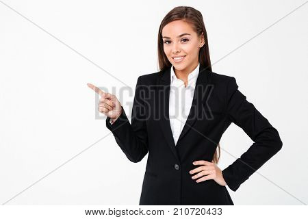 Image of happy business woman standing isolated over white background. Looking camera pointing to copyspace.