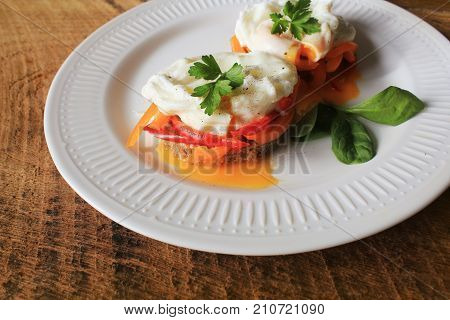 Eggs Benedict. Toasted muffins with paprika, spinach, poached eggs .