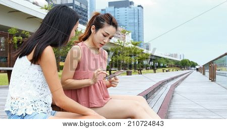 Friends chatting and looking at cellphone together 