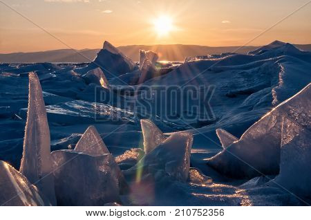Field of ice hummocks on the frozen Lake Baikal. Sunset. Russia