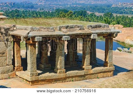 View of ancient ruins on Hemakuta hill in Hampi, Karnataka, India. Landscape with unique mountain formation with tropical nature on the horizon and old hindu temple. UNESCO World Heritage Site