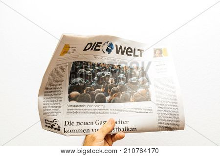 PARIS FRANCE - OCT 2 2017: Man reading Die Welt German newspaper with reporting headlines about the unrest protests in Catalonia referendum