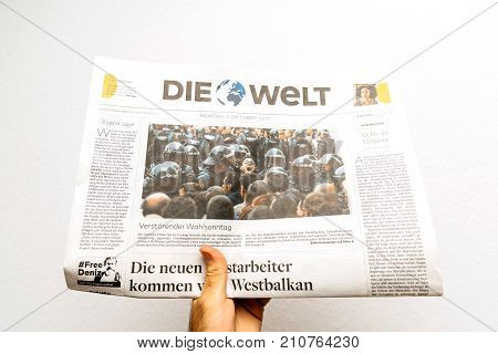 PARIS FRANCE - OCT 2 2017: Man reading Die Welt German newspaper with reporting headlines about the unrest protests in Catalonia referendum