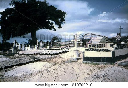 NUKU'ALOFA / TONGA - CIRCA 1990: Graves in a cemetery in Nuku'alofa, on the island of Tongatapu, are decorated with empty bottles and other items.
