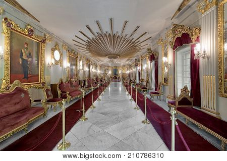 Cairo, Egypt - October 21, 2017: Throne Hall at Manial Palace of Prince Mohammed Ali Tewfik with ornate ceiling inspired by the old flag of the ottoman empire gold plated armchairs and red carpets Cairo Egypt