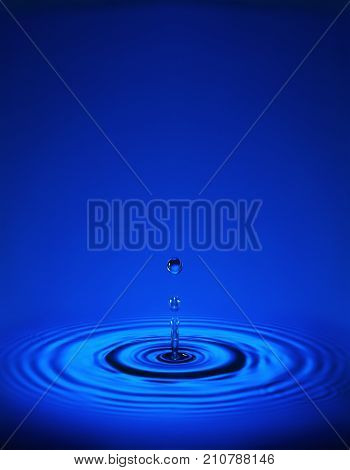 Water Drop With Ripples In Blue Water