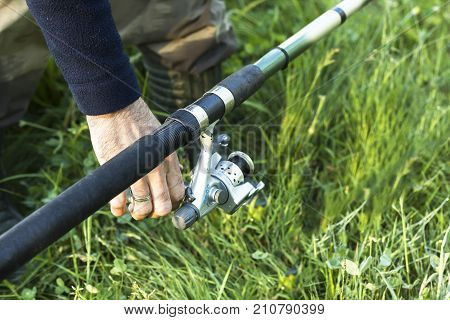 The angler's hands put the bait in the groundbait box