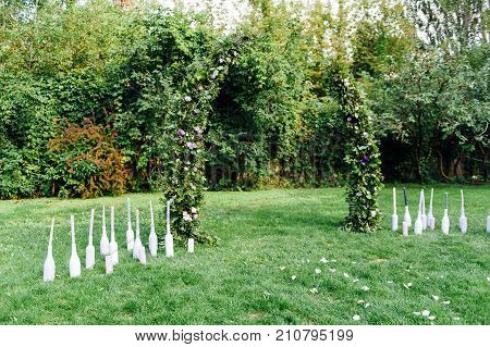 Place for wedding ceremony with white chairs and an arch of living plants