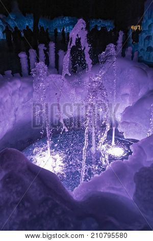A water fountain made of ice lit up purple.