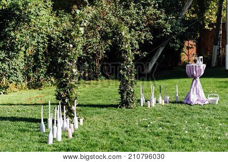 Place for wedding ceremony with white chairs and an arch of living plants