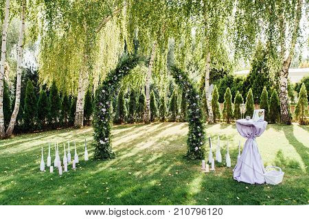 Place for wedding ceremony with white chairs and an arch of living plants