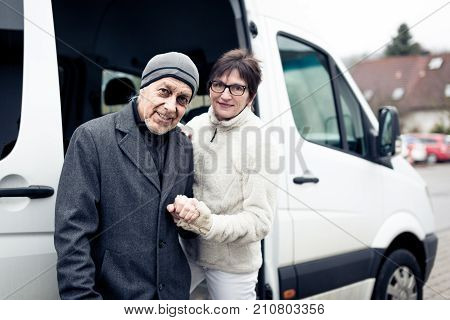 nurse helping senior man enter a van