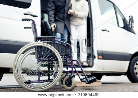 nurse helping senior man exit a van and get to his wheelchair