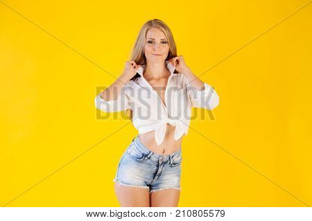 beautiful blonde with blue eyes posing on a yellow background 1