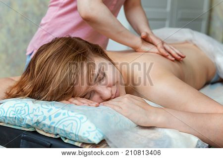 Beautiful young girl having massage in spa salon