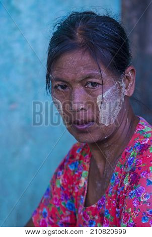 MANDALAY MYANMAR - SEP 03 : Portrait of Burmese woman with thanaka on face on Mandalay Myanmar on September 03 2017. Thanaka is paste made from ground bark