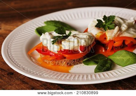 Eggs Benedict. Toasted muffins with paprika, spinach, poached eggs