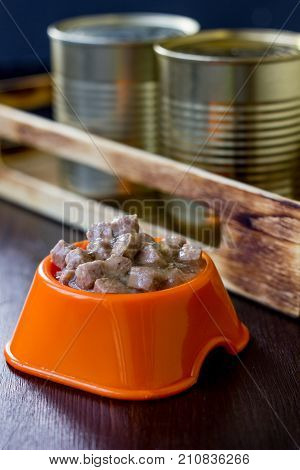 Canned pet food in a orange plastic bowl