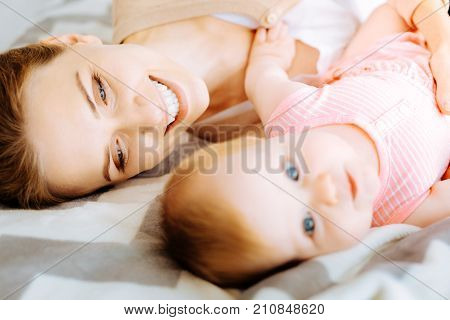 Close people. Positive emotional loving mother looking kindly at her dearest little baby