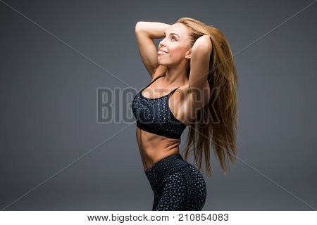 Fit Beautiful And Young Athletic Woman Standing In A Relaxed Pose, Big Smile And Wearing A Grey And