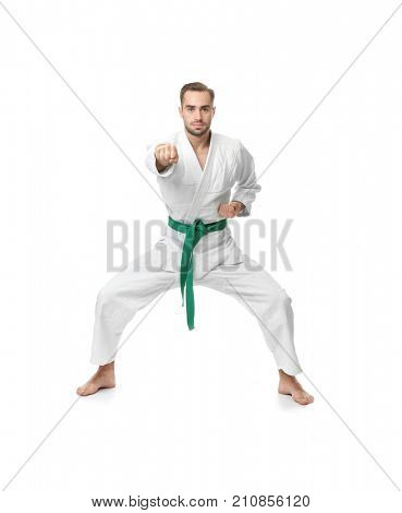 Young man practicing karate on white background