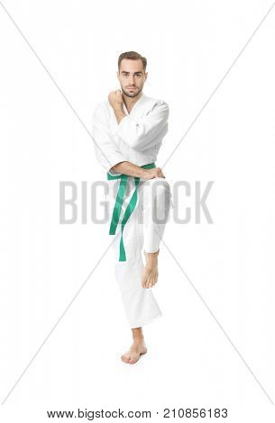 Young man practicing karate on white background