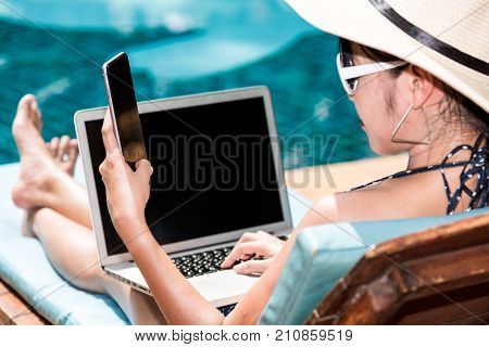 Beautiful Woman Working On Laptop And Mobile Smart Phone Near Swimming Pool