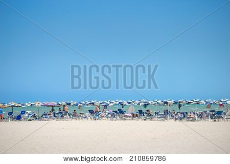White Beaches Italy. Sea Sky People Umbrellas Sun Beds.