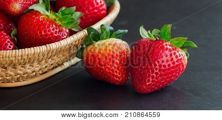 Goodness ripe strawberries on granite table with copy space use for web banner or cover and other web design.Red freshness strawberry on black isolated background in low key or still life concept. Fresh strawberry background for web design.