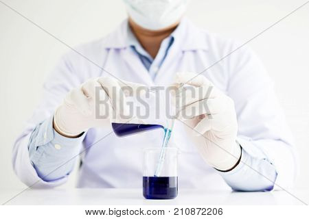scientists and scientific equipment Pouring mixing reagents liqiud beakerLaboratory research chemistry concept