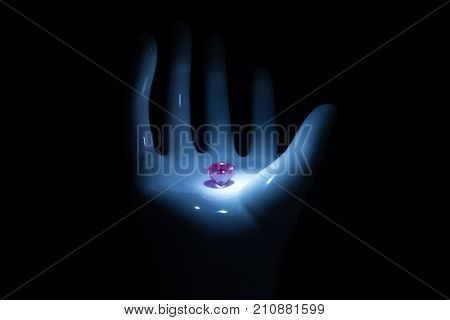 Diamond jewel isolated. Beautiful shape pink brilliant image with reflective surface in the palm of a hand on black background.